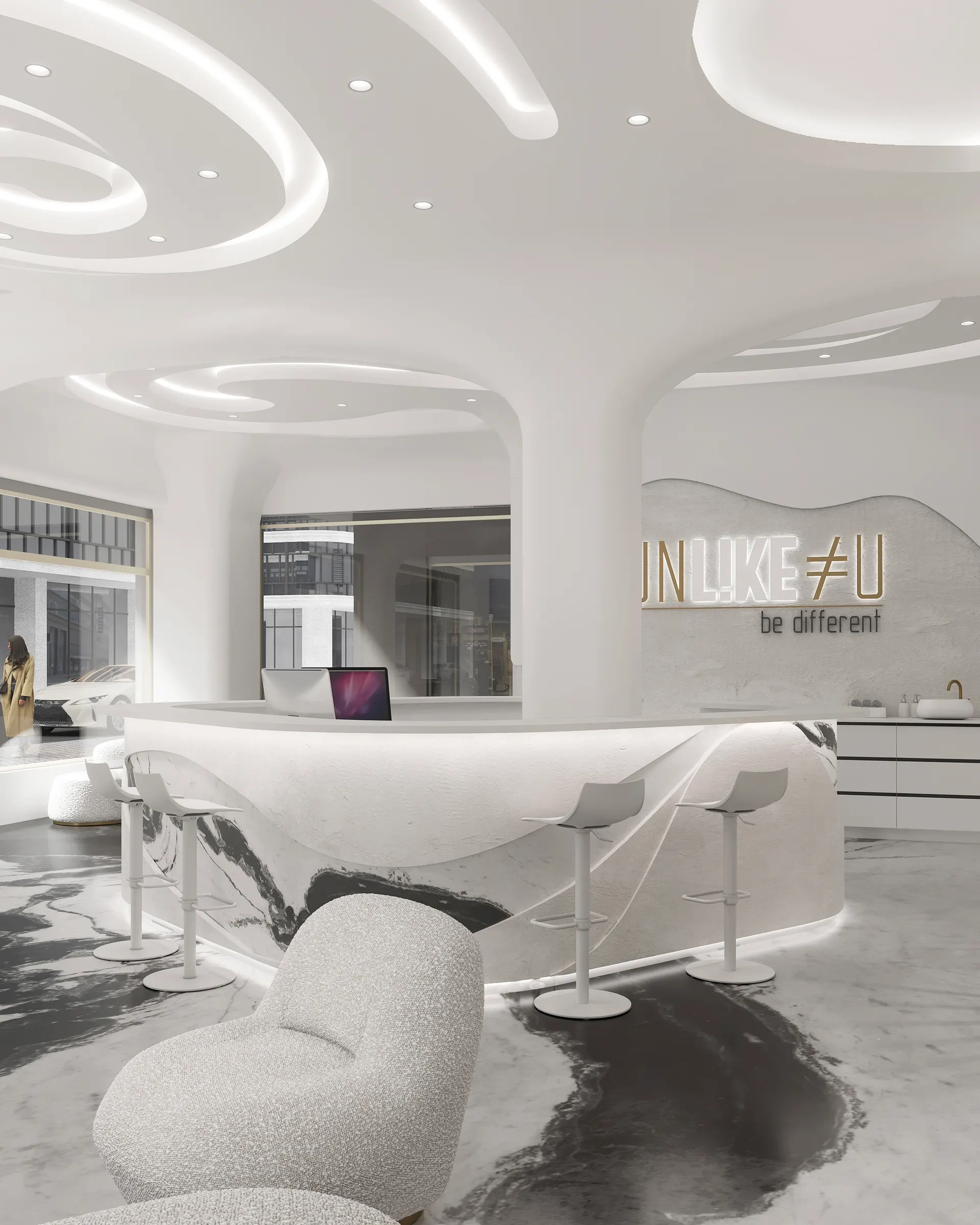 Studio reception with a curved marble counter and illuminated lettering