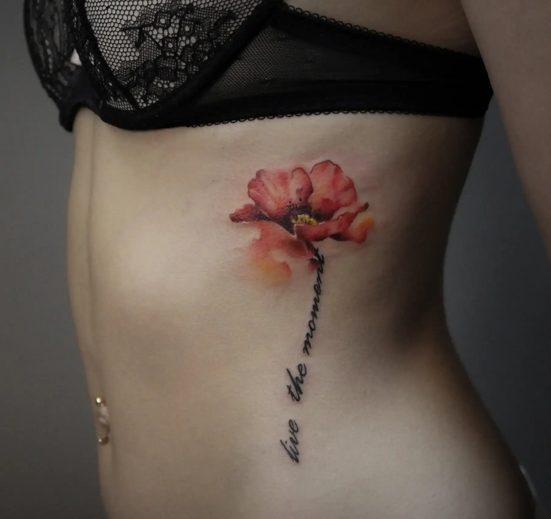 Roter Mohn mit Schriftzug an der Rippe – Colour Tattoo