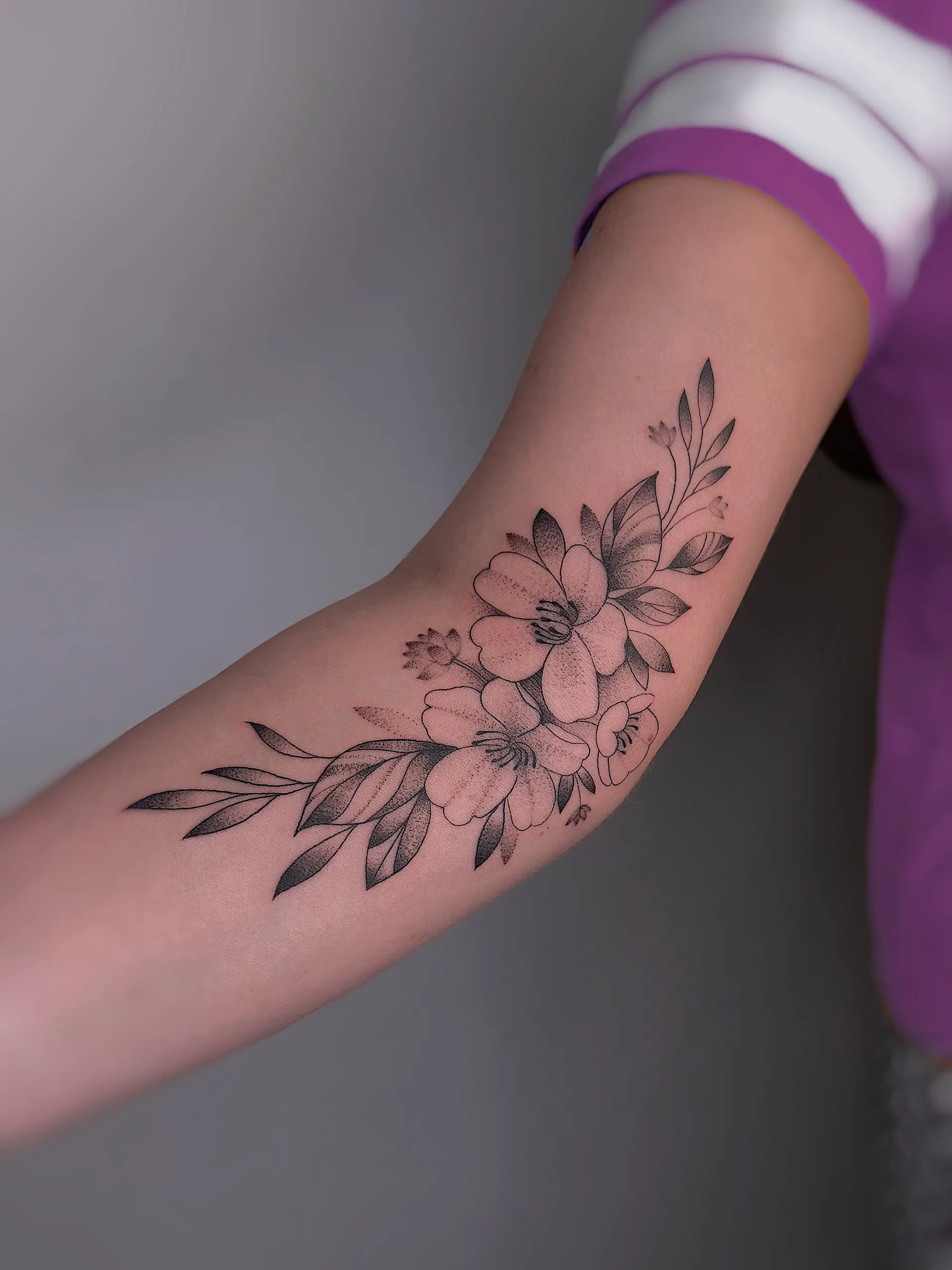 Blumenranke am Oberarm – Fineline Tattoo