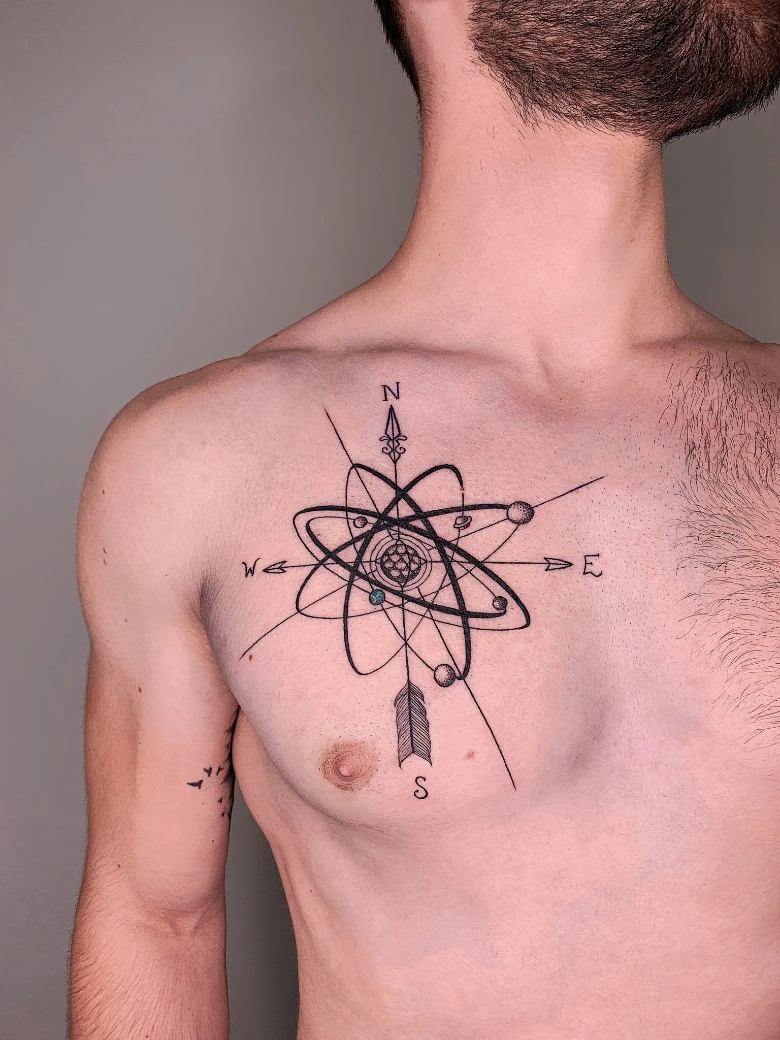 Kompass und Atom auf der Brust – Fineline Tattoo