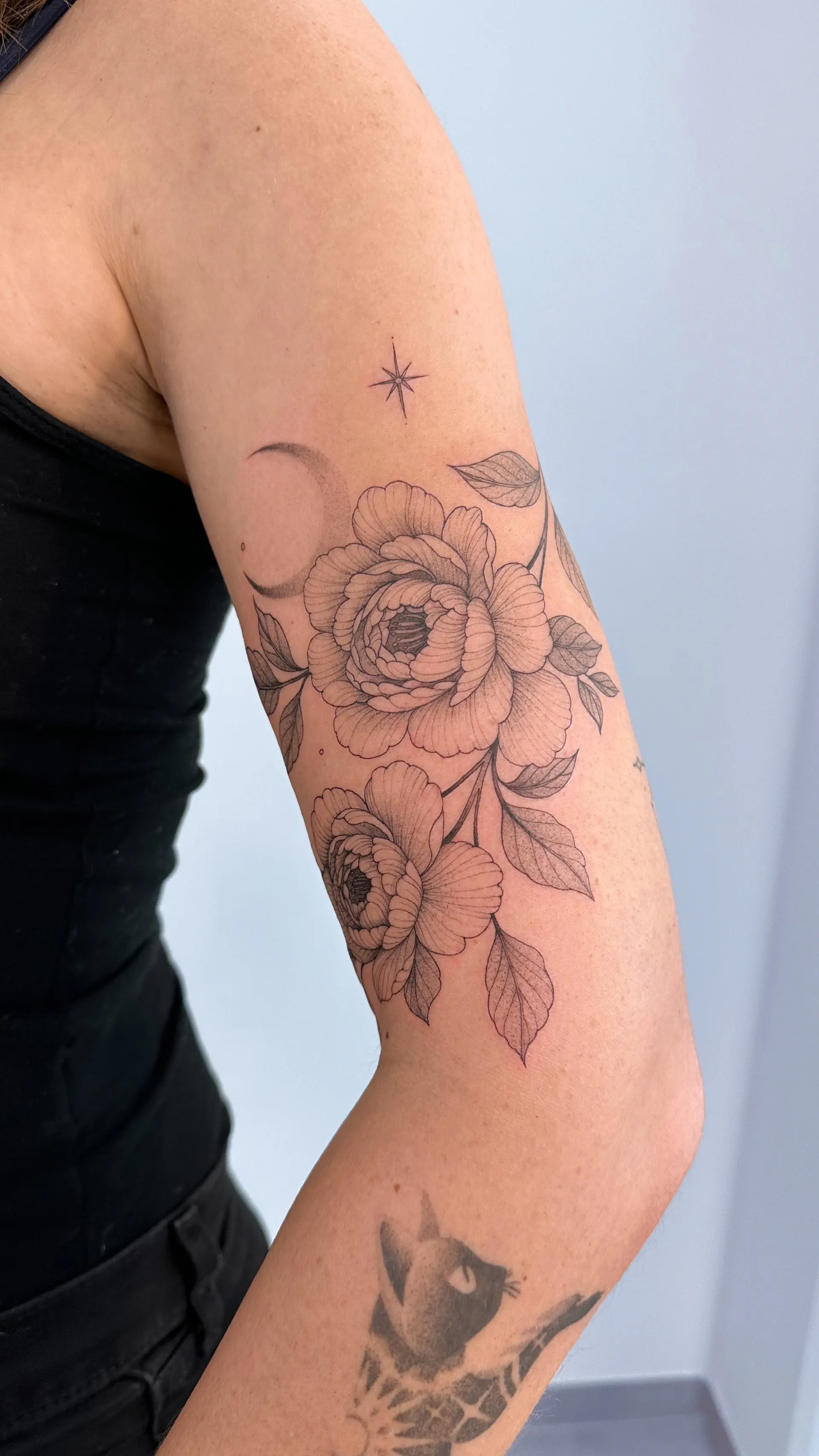 Rosen mit Mond und Stern am Oberarm – Fineline Tattoo