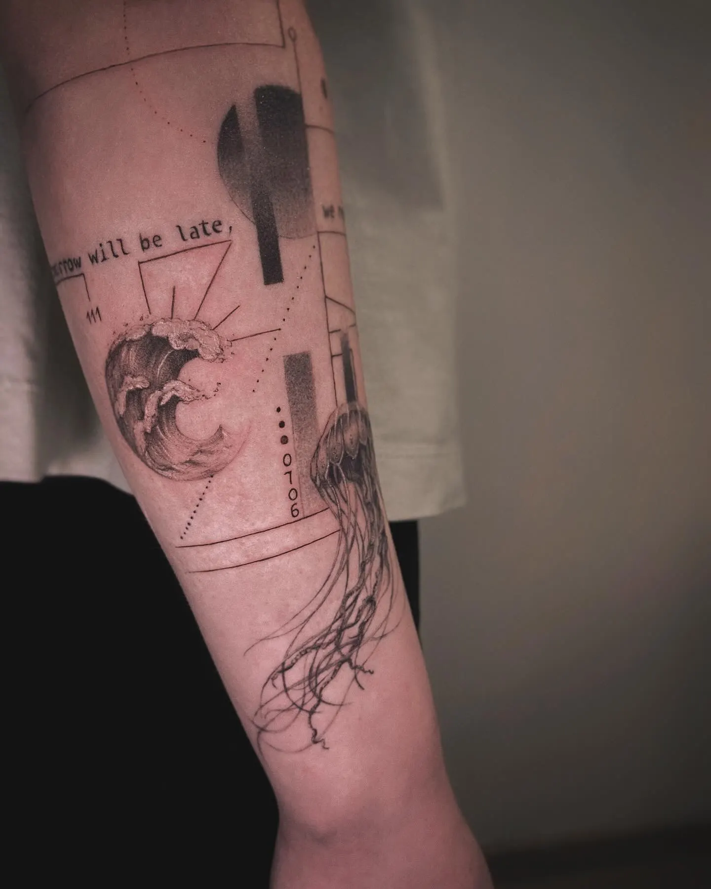 Graphic fine-line tattoo on a forearm with a wave and jellyfish