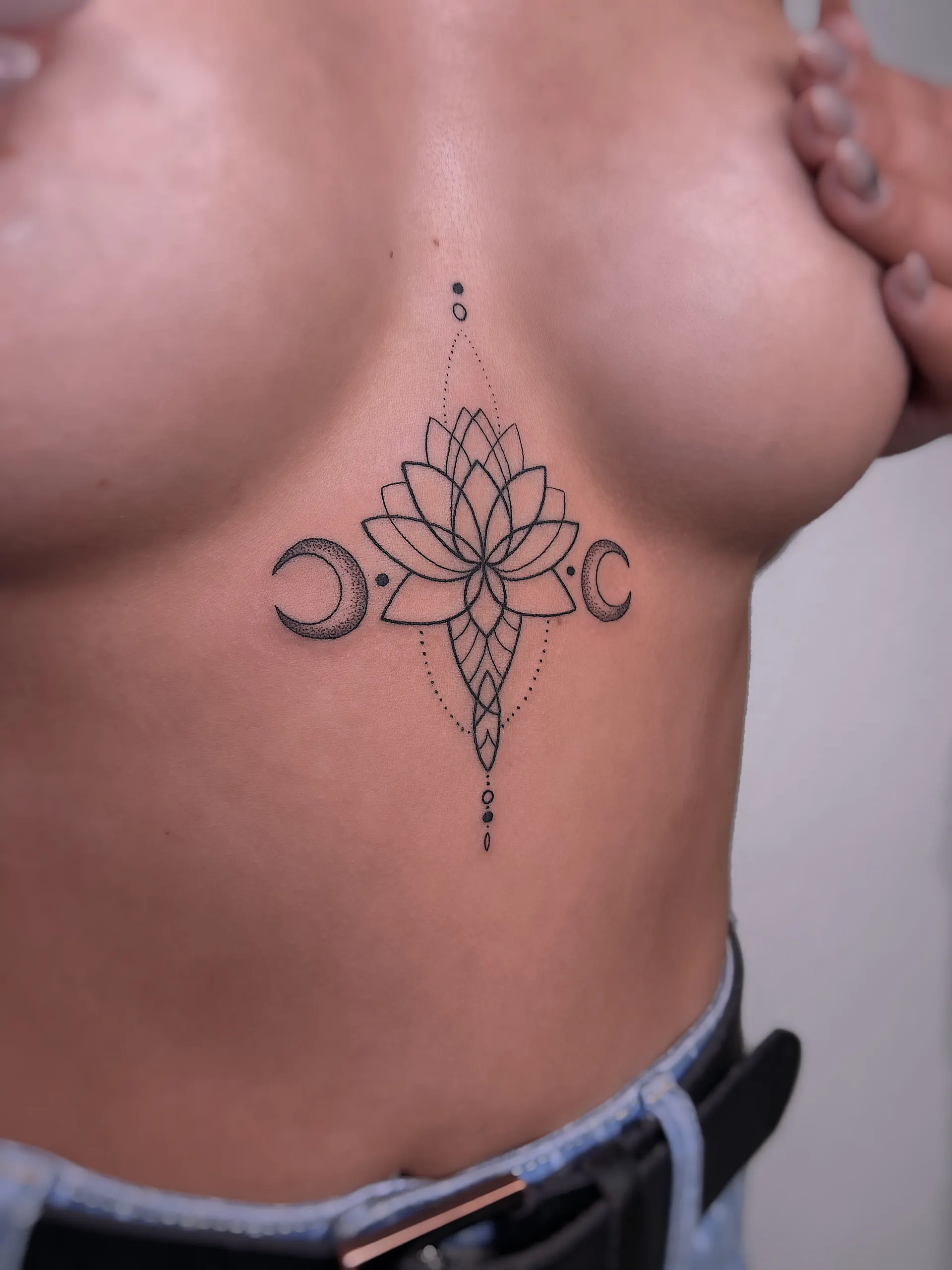 Lotus mit Mondsicheln unter der Brust – Ornamental Tattoo